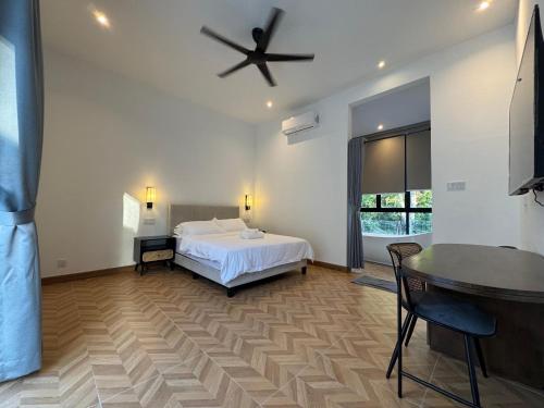 a bedroom with a bed and a ceiling fan at The Rubber Escape, Melaka in Melaka