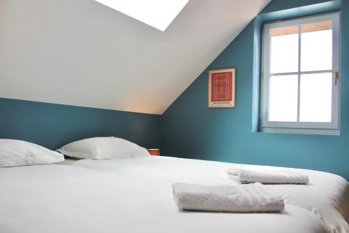 a bedroom with a large white bed with a window at La Bullote - Gîtes - Paris Roissy CDG in Villeneuve-sous-Dammartin