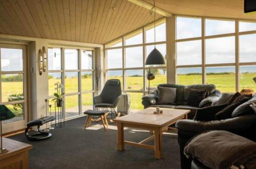 a living room with a couch and a table and windows at AE301-Aeroskobing-Skraningen-12 in Ærøskøbing