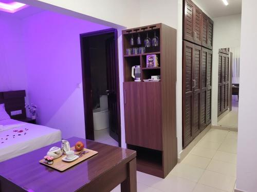 Habitación de color púrpura con cama y mesa en Sheyllo Suites Abidjan - Cocody, en Abiyán