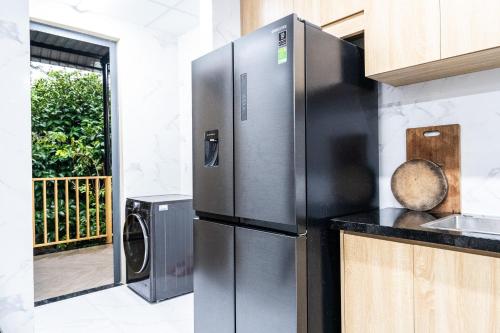 a stainless steel refrigerator in a kitchen with a balcony at Lumiere Family Village Long Khánh - Đồi Rìu in Long Khanh