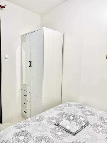 a white bedroom with a bed and a dresser at The Urban Haven Cebu 2Bedrooms 4beds Condo in Mandaue City