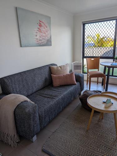 a living room with a couch and a table at Cosy, self-contained and central to everywhere in Gold Coast