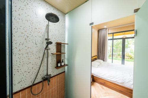 a room with a bedroom with a bed and a shower at Lumiere Family Village Long Khánh - Đồi Rìu in Long Khanh
