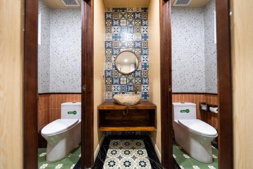 a bathroom with two toilets and a mirror at Lumiere Family Village Long Khánh - Đồi Rìu in Long Khanh