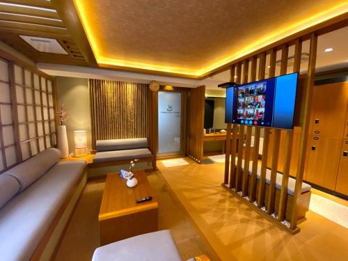 a living room with a couch and a flat screen tv at Flower Hotel Ulaanbaatar in Ulaanbaatar