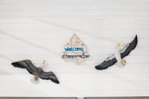 two birds on a wall with a welcome sign at AE298-Aeroskobing-Rosenstraede-36 in Ærøskøbing