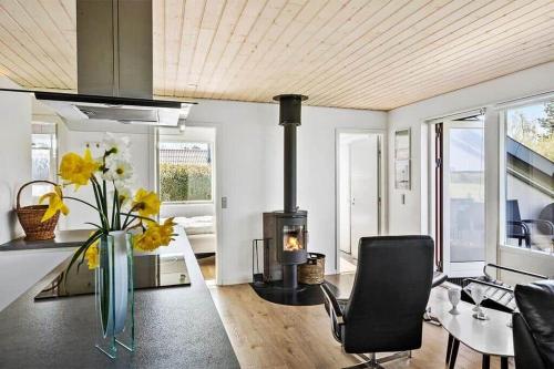 een woonkamer met een open haard en een vaas met bloemen bij SB50301-Sydals-Solbjergvej-7 in Sønderby