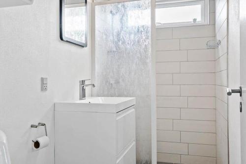 een witte badkamer met een wastafel en een douche bij SB50301-Sydals-Solbjergvej-7 in Sønderby
