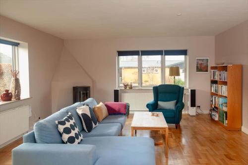 a living room with a blue couch and two chairs at AE265-Aeroskobing-Sotoften-12 in Ærøskøbing