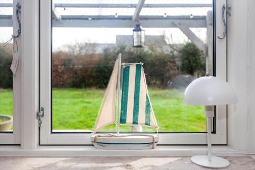 a toy boat sitting in a window next to a lamp at AE265-Aeroskobing-Sotoften-12 in Ærøskøbing