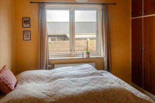 a bedroom with a bed in front of a window at AE265-Aeroskobing-Sotoften-12 in Ærøskøbing