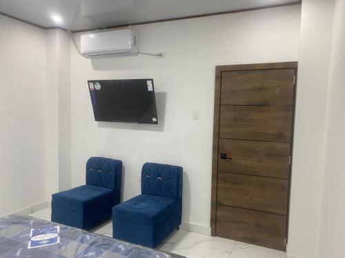two blue chairs in a room with a tv at Villa Bonita in Portoviejo