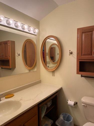 a bathroom with a sink and two mirrors at Cozy Downtown Hunter Mountain Getaway in Hunter