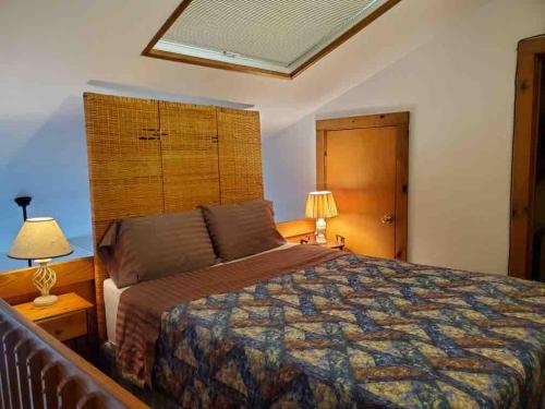 a bedroom with a bed and a lamp and a window at Cozy Downtown Hunter Mountain Getaway in Hunter