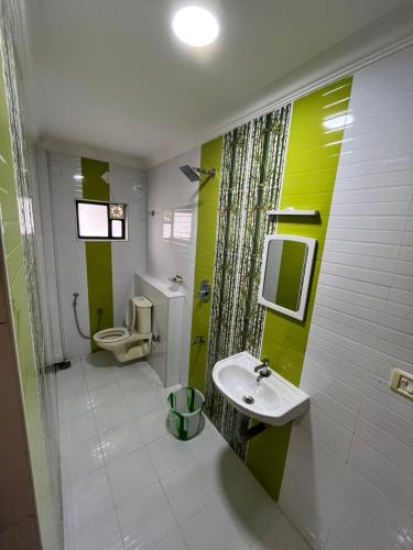 une salle de bain avec un lavabo et des toilettes dans l'établissement Hill side Harmony, à Idukki