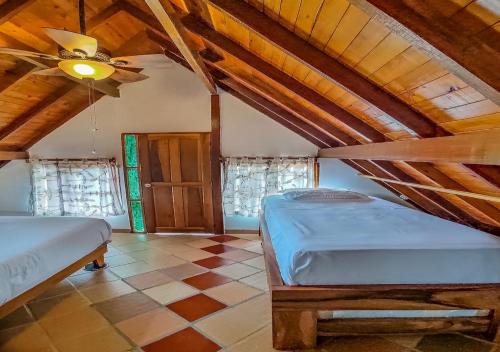 a bedroom with two beds and a ceiling fan at Finca VIP de lujo privada, jacuzzi y paz cerca de la piedra de Guatape in Guatapé