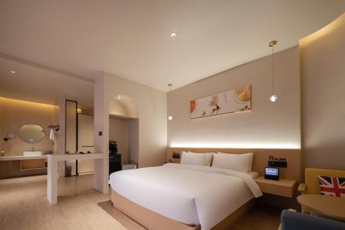 a bedroom with a large white bed and a bathroom at Langying Intelligent Guesthouse in Changshancun