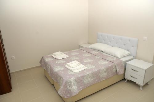 a bedroom with a bed and a nightstand with towels on it at Saatli Suites in Cesme