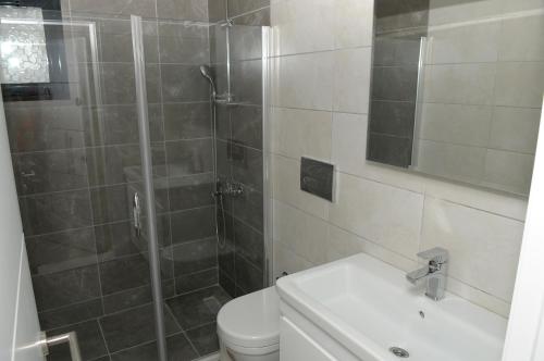 a bathroom with a shower and a toilet and a sink at Saatli Suites in Cesme