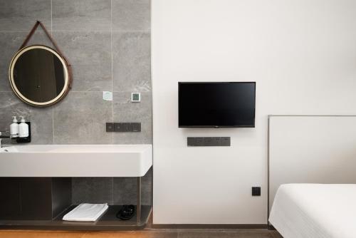 a bathroom with a sink and a tv on the wall at Meichen Beijing Daxing International Airport in Beijing