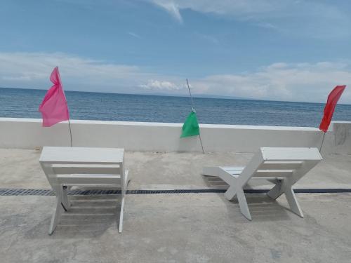 two umbrellas and a table and two chairs on a balcony at Angler's Hub & Resort Oslob in Oslob