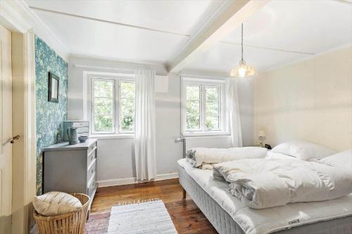 a bedroom with a bed and a table and windows at AE222-Marstal-Trouslokkevej-1 in Marstal