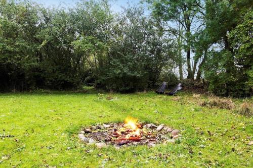 a fire in the middle of a field with two benches at AE222-Marstal-Trouslokkevej-1 in Marstal