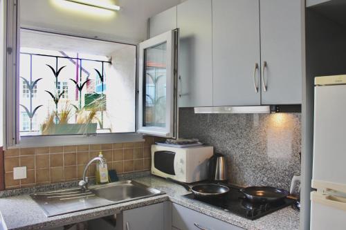 a kitchen with a sink and a microwave at La Bullote - Gîtes - Paris Roissy CDG in Villeneuve-sous-Dammartin