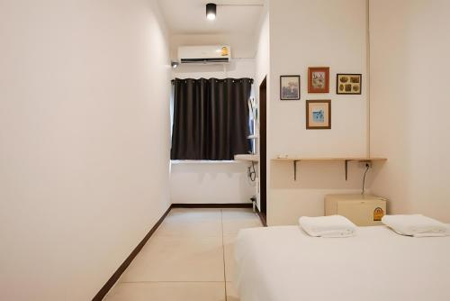 two beds in a small room with a window at XX GO INN Asiatique Bangkok โก อินน์ เอเชียทีค เจริญกรุง in Bangkok
