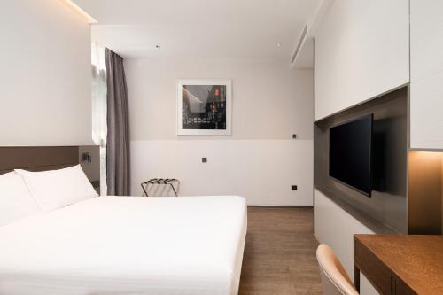 a bedroom with a bed and a flat screen tv at Meichen Beijing Daxing International Airport in Beijing