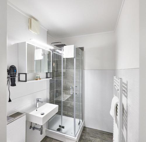 a white bathroom with a sink and a shower at Frische Brise - 2.11 in Cuxhaven