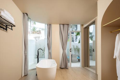 a bathroom with a white tub and a large window at Langying Intelligent Guesthouse in Changshancun