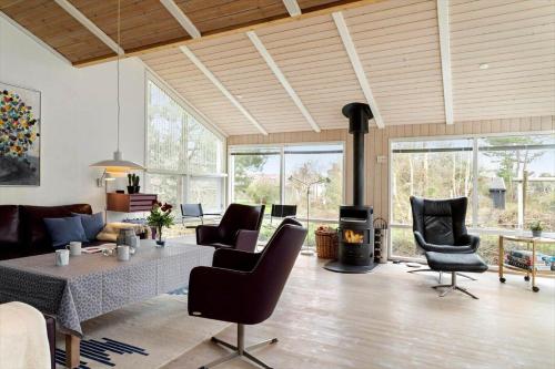 a living room with a table and chairs and a fireplace at 20128-Samso-Maarup-Osterstrand-60 in Nordby