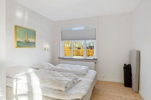 two beds in a white room with a window at AE287-Marstal-Kirkevejen-38 in Marstal