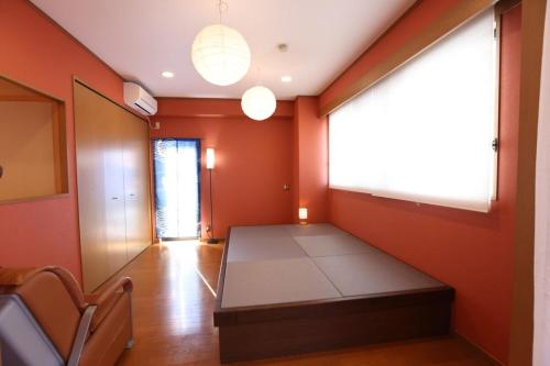 a room with orange walls and a bench in it at SN62 大須駅鶴舞駅最寄り 栄まで徒歩圏内 最大12名 3家族分の個室 お風呂からのスカイビュー Nearst to Osu Tsuruma Station Within walking distance to Sakae Private room for up to 12 people 3 families Sky view from the bath in Nagoya