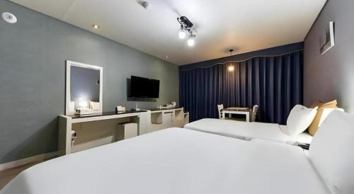 a hotel room with two beds and a television at BENIKEA Technovalley Hotel in Daejeon