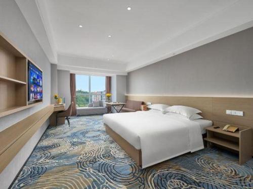 a bedroom with a large white bed and a large rug at Grand Nest Hotel (Tang Jia Wan Beach) in Zhuhai