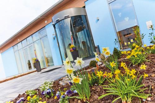 a garden of flowers in front of a building at Vital Hotel an der Therme GmbH in Bad Windsheim