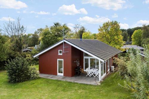 a red barn with a deck in a yard at AE245-Aeroskobing-Skraningen-4 in Ærøskøbing
