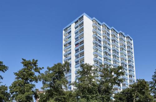 a tall white building with trees in front of it at Frische Brise - 2.11 in Cuxhaven
