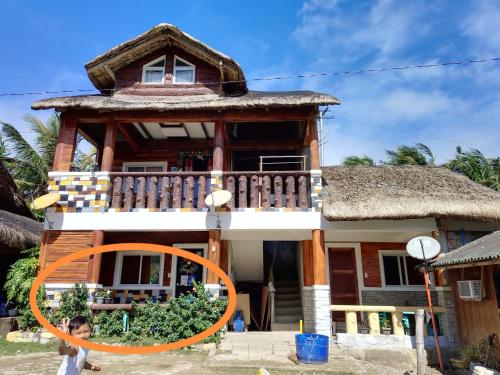 a child standing in front of a house at Mekeni transient house and restaurant in Pagudpud