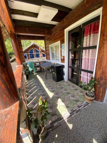 a screened in porch with a table and a bench at Mekeni transient house and restaurant in Pagudpud