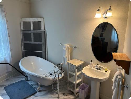a bathroom with a tub and a sink and a mirror at The Currier Inn in Greeley