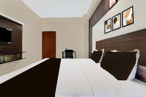 a bedroom with a large white bed in a room at Collection O Republic Mall Coimbatore Formerly Manis Residency in Coimbatore