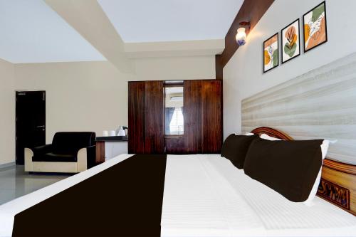 a living room with a bed and a chair at Collection O Republic Mall Coimbatore Formerly Manis Residency in Coimbatore
