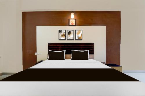a bedroom with a large white bed with two pillows at Collection O Republic Mall Coimbatore Formerly Manis Residency in Coimbatore