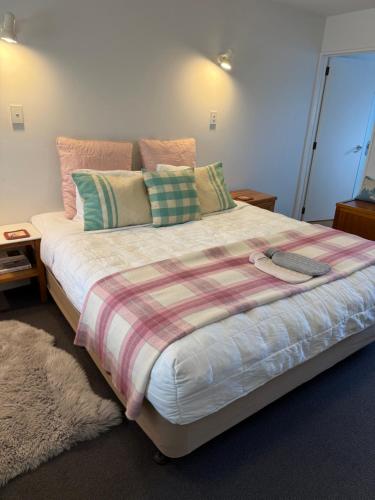 a bedroom with a large bed with a blanket on it at #2 Glenorchy Alpine Suite in Glenorchy