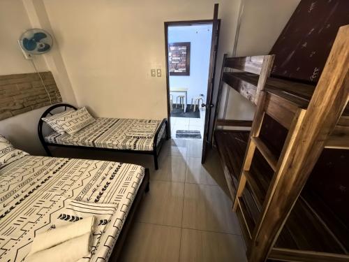 two beds sitting in a room with a staircase at SILVERISE Pension in El Nido