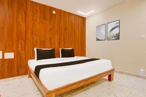 a bed in a room with a wooden wall at Super Townhouse Sri Padmavati Ammavaari Temple Formerly Hotel Rama Grand in Tirupati